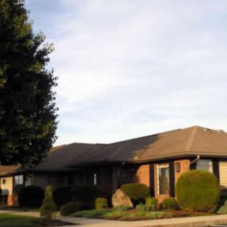 A suburban house with a well-maintained lawn and landscaping.