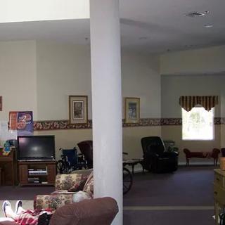 A spacious living room with a television, seating area, and decorative elements.