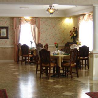 A well-lit dining area with tables and chairs arranged neatly, featuring elegant decor.