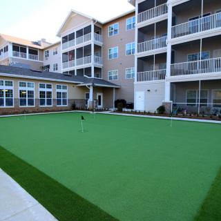 A modern apartment complex featuring spacious balconies and a well-maintained lawn area.