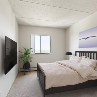 A modern and minimalist bedroom with a cozy bed, wall-mounted TV, and simple decor.