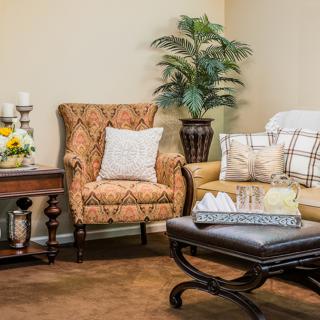 A cozy living room with an armchair, sofa, and decorative elements.