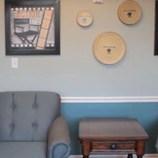 A cozy living room corner with an armchair, side table, and decorative wall art.