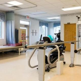 A physical therapy room equipped with exercise machines and rehabilitation tools.