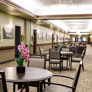 A spacious and elegantly decorated lobby area with tables and chairs along a corridor.
