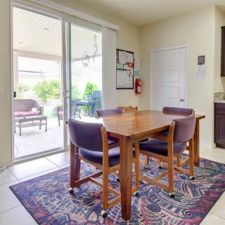 A cozy dining area with a wooden table and chairs, set on a patterned rug near a sliding glass door letting in natural light.