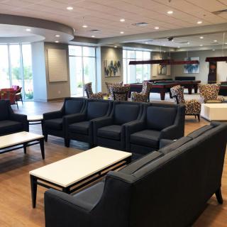 A modern and spacious lounge area with comfortable seating and ample natural light.