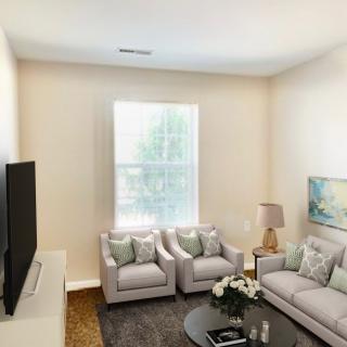 A cozy living room featuring comfortable sofas, a large TV, and elegant decor.