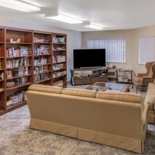 A cozy living room with bookshelves, a television, and comfortable seating.