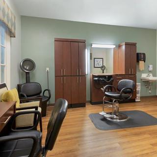 A well-equipped salon with styling chairs, mirrors, and hair drying equipment.