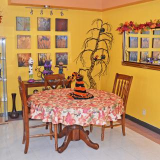 A cozy dining room decorated with Halloween and autumn-themed accents, featuring a table with a festive cloth and seasonal centerpiece.