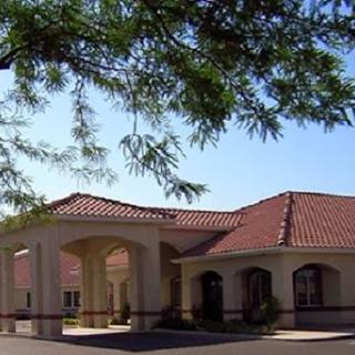 A charming building surrounded by trees under a clear blue sky.