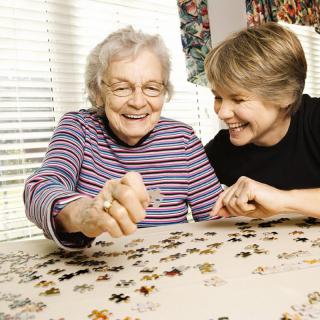 Two women enjoying a puzzle together.