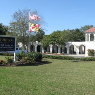 A picturesque view of a building featuring the flags of the United States and Maryland in a landscaped area.