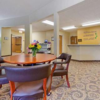 A cozy office reception area with a round table and chairs, decorated with flowers.