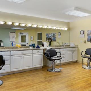 A hair salon interior with styling chairs, mirrors, and cabinets.