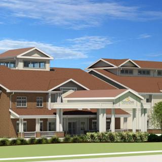 A modern residential building with a multi-tiered roof and large windows, set against a clear blue sky.