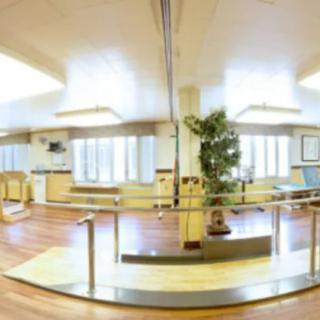 A spacious rehabilitation center equipped with exercise equipment and a bright, welcoming atmosphere.
