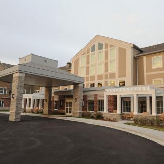 A modern building with a covered entrance and large windows.