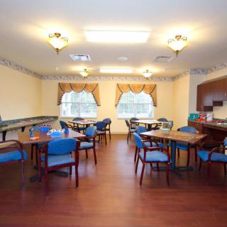 A well-lit dining room with tables and chairs arranged neatly.