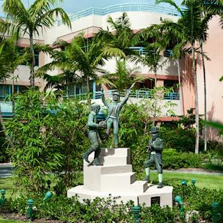 A beautiful outdoor sculpture surrounded by lush greenery and palm trees, creating a serene atmosphere.