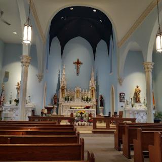 A serene view of the interior of a church, showcasing the altar and wooden pews.
