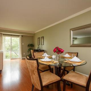 A stylish dining room featuring a round table set for a meal, complemented by elegant decor and natural light.