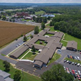 Aerial view of a school campus with surrounding fields and parking areas.