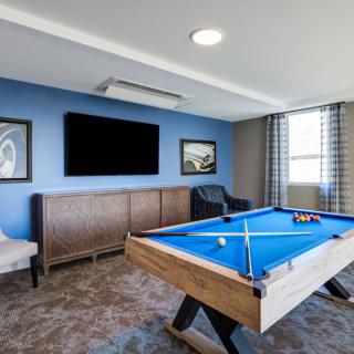 Modern game room featuring a pool table and wall-mounted television.