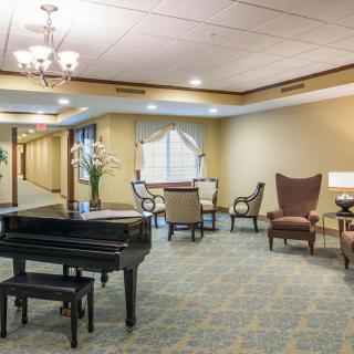 A well-appointed lobby with a grand piano, elegant seating, and soft lighting.