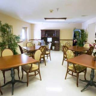 A well-lit dining area with wooden tables and chairs, complemented by indoor plants.