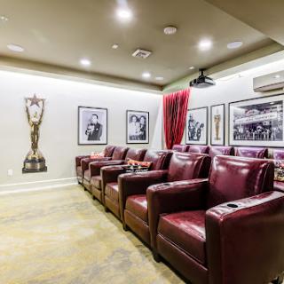 A stylish home theater featuring comfortable recliners and unique wall decorations.