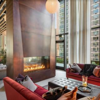 A luxurious modern living room with a sleek fireplace and large windows overlooking the city.