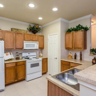 A modern kitchen with wooden cabinets, white appliances, and a clean countertop.