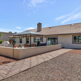 A view of a backyard with a patio area and gravel landscaping under a clear blue sky.