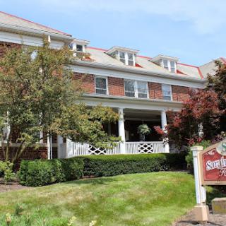 A charming residential building featuring classic architecture and well-maintained landscaping.