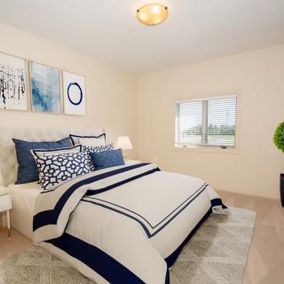 A modern and cozy bedroom with elegant decor and neutral color tones.