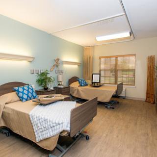 A well-lit hospital room with two patient beds, designed for comfort and care.