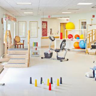 A well-equipped physical therapy room with exercise machines and therapy tools.