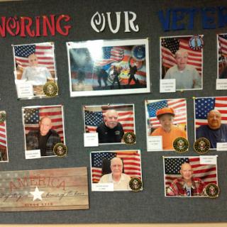 A tribute display honoring veterans, featuring their photographs against a backdrop of the American flag.