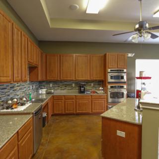 A spacious kitchen with wooden cabinets and modern appliances.