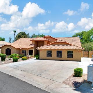A beautiful single-story house with a tiled roof and landscaped front yard.