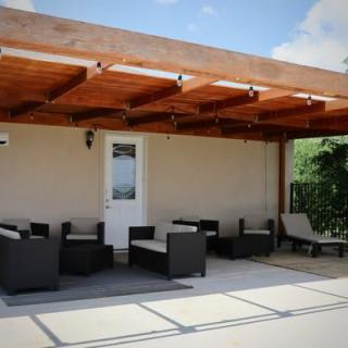 A relaxing outdoor patio with a wooden pergola and comfortable seating.