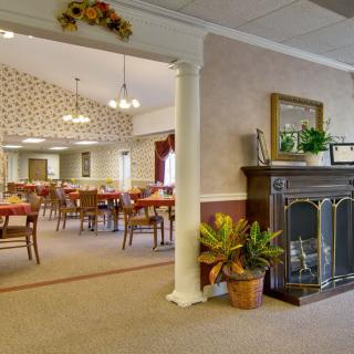 A warmly decorated dining area with a fireplace and seating for guests.