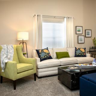 A cozy and modern living room featuring a stylish sofa, vibrant armchair, and attractive decor.