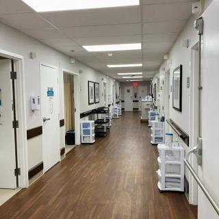 A clean and well-lit hospital hallway with medical equipment along the walls.
