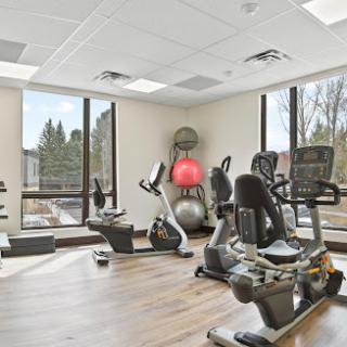 A bright and modern gym space featuring various exercise equipment, designed for fitness enthusiasts.