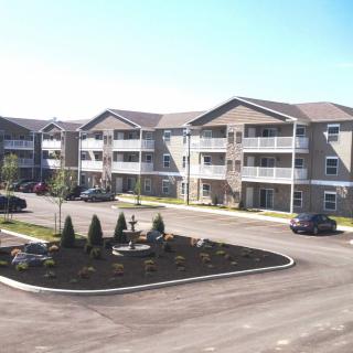 A suburban apartment complex with a neatly landscaped parking area.