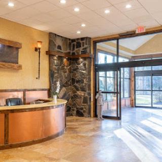 A welcoming hotel lobby featuring a stylish reception desk and natural stone accents.