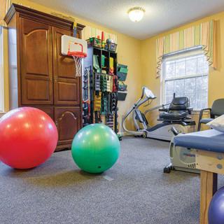 A therapy room equipped with exercise balls and a stationary bike for fitness and rehabilitation activities.
